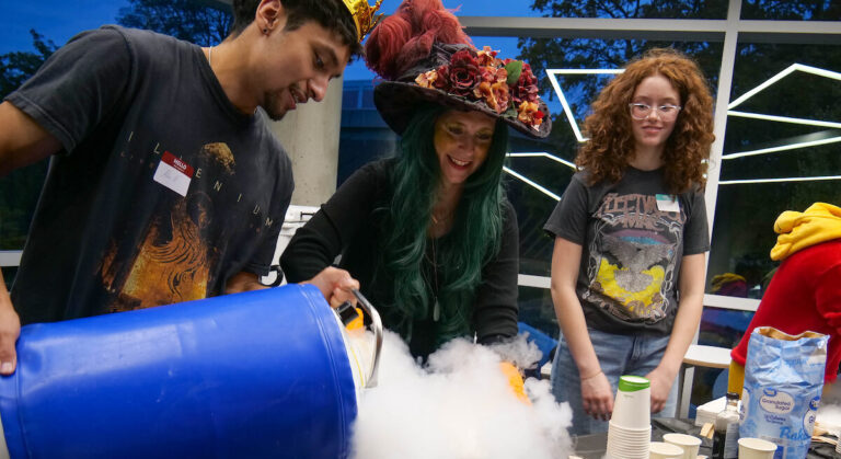 Three students with experiment that has fog.