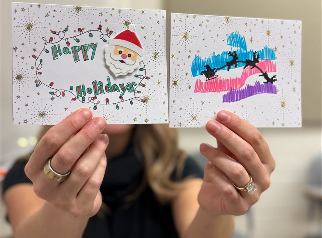 Photo of hands holding up two handmade cards.